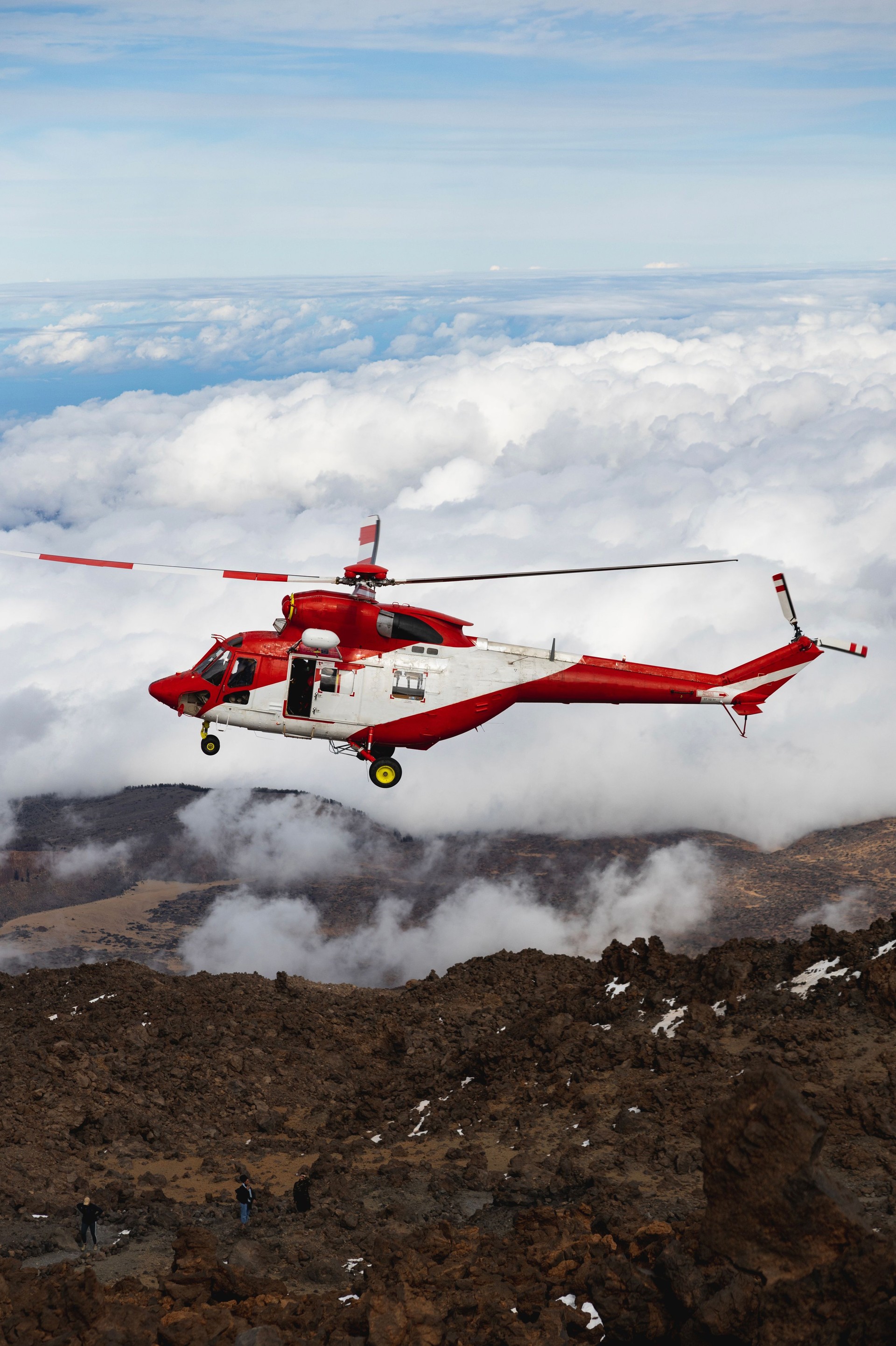 Alpine helicopter flies over mountains